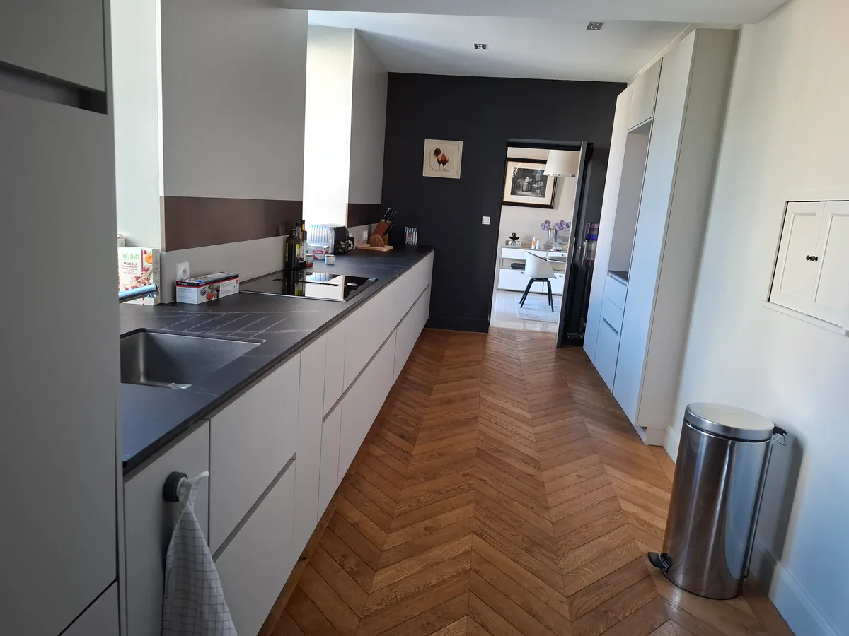 Cuisine contemporaine avec rangements intégrés, plan de travail et parquet