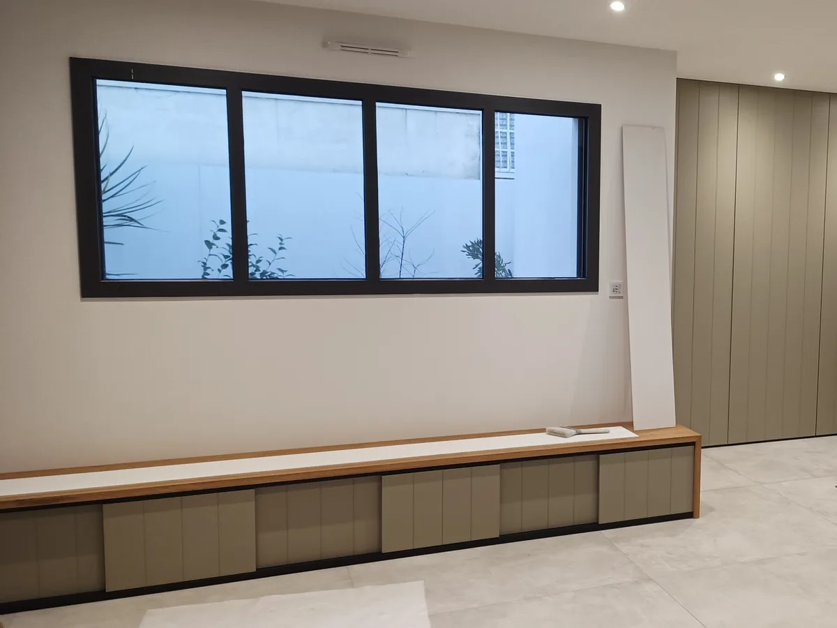 Rangements muraux et assise intégrée dans un intérieur en rénovation