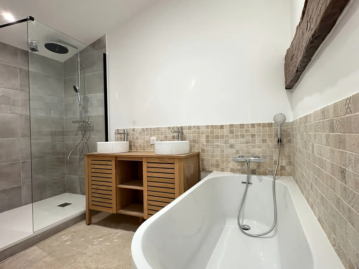 Salle de bain rénovée avec douche, baignoire et double vasque